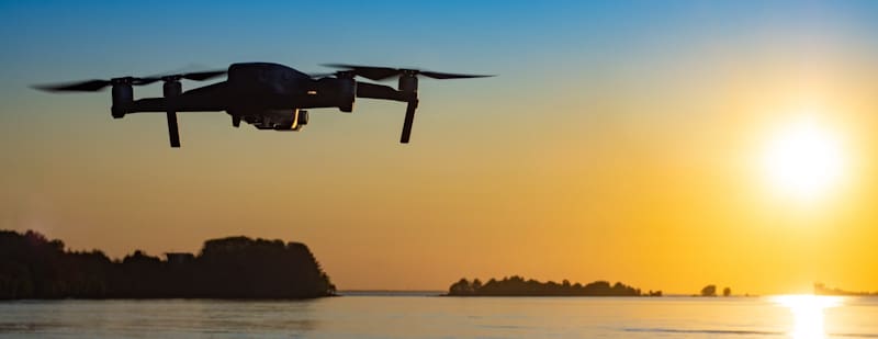 drone flies over water in sunset no pilot on sight