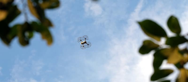quadcopter with propeller protectors flies in the distance