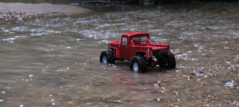 rc truck red crossing a river