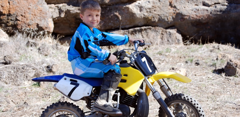 kid sits on child size dirt bike